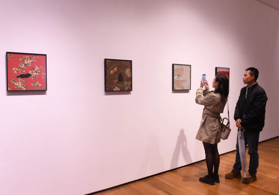 图为精美艺术作品吸引参观者驻足欣赏拍照。周毅 摄